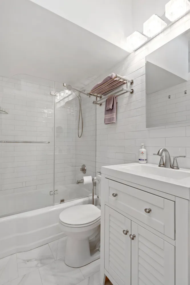 a bathroom with a toilet a sink a mirror a bathtub and vanity