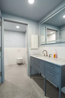 a spacious bathroom with a sink a toilet and a mirror