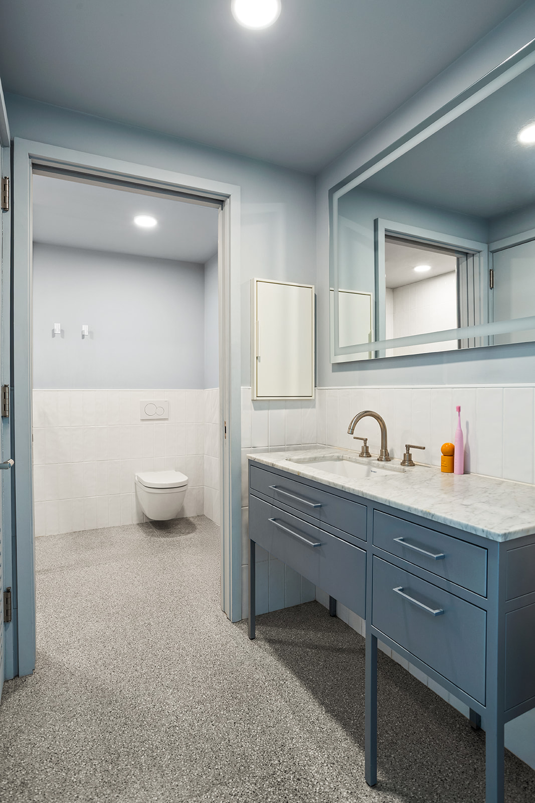 547 West 47th Street, Unit 1102 Manhattan, NY 10036 - Photo 7 of 19 a spacious bathroom with a sink a toilet and a mirror