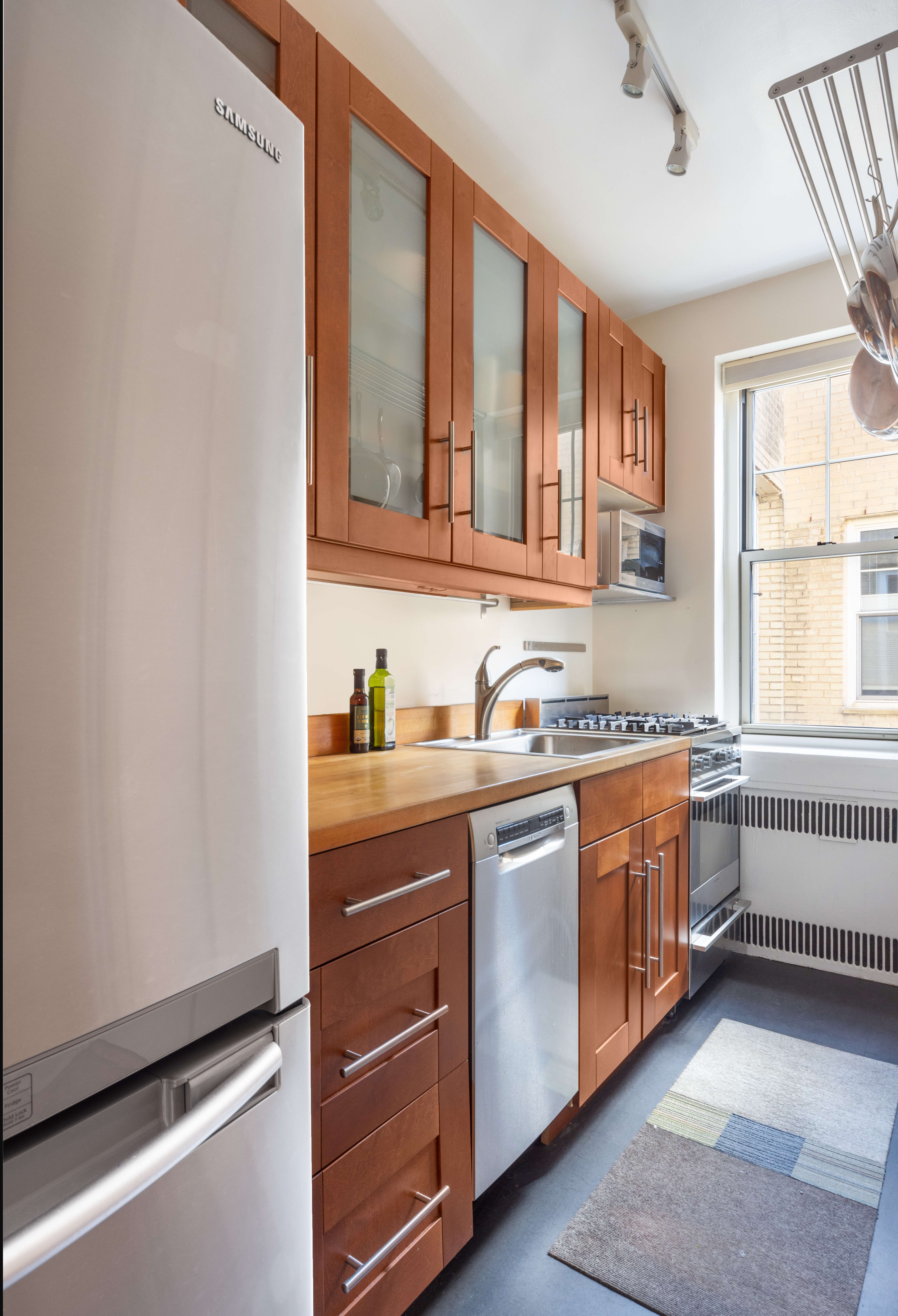 720 Fort Washington Avenue, Unit 6M Manhattan, NY 10040 - Photo 5 of 18 a kitchen with stainless steel appliances granite countertop a sink and a stove next to a window