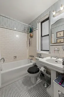 a bathroom with a sink a toilet a mirror a bathtub and shower