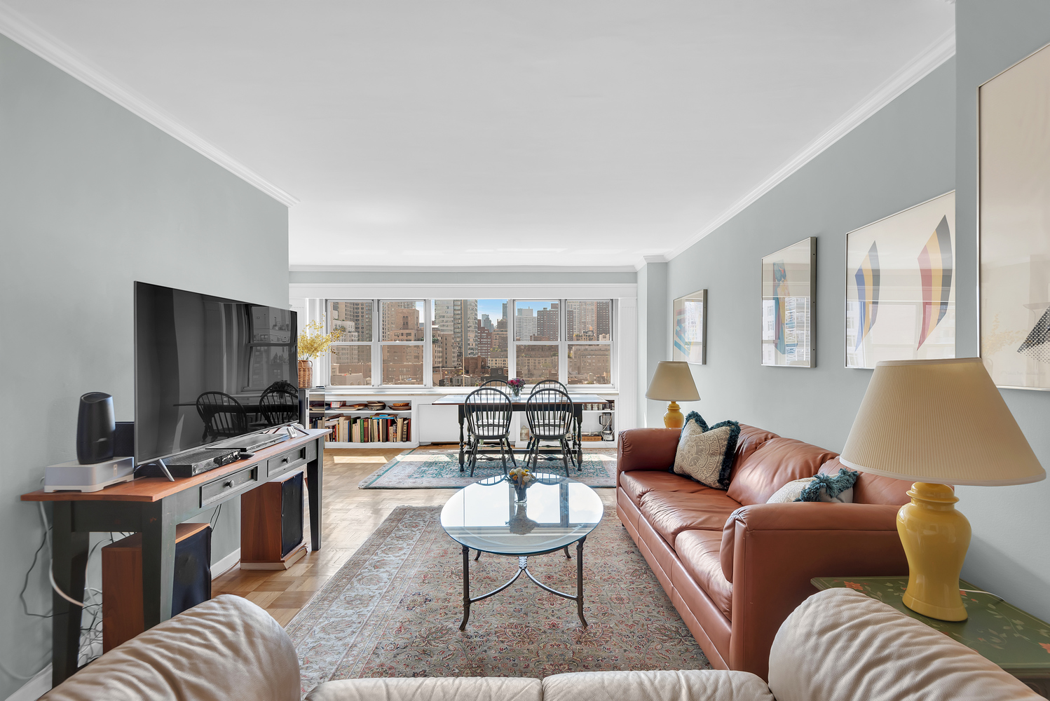 230 East 79th Street, Unit 12F Manhattan, NY 10075 - Photo 1 of 7 a living room with furniture and a flat screen tv