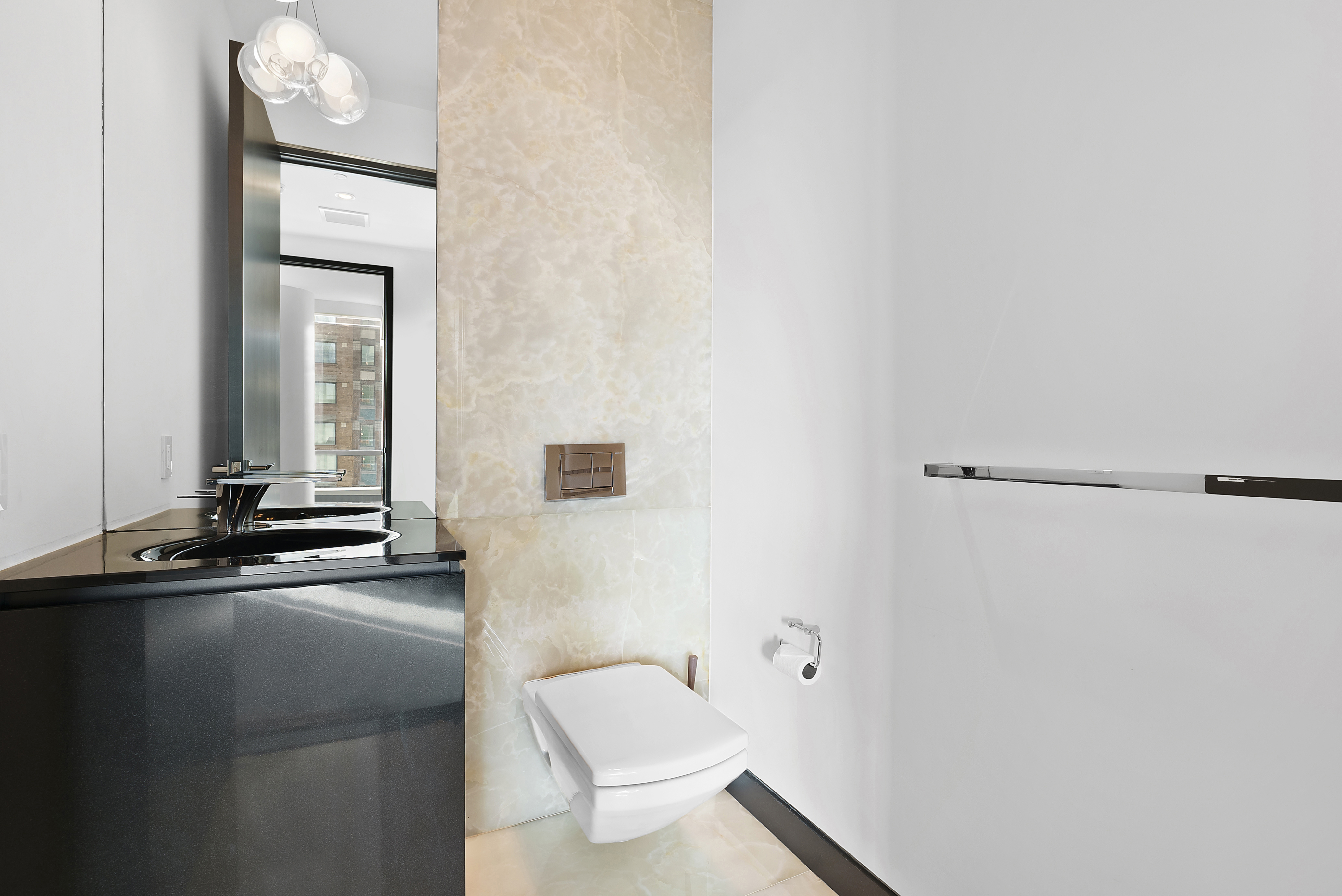 157 West 57th Street, Unit 49B Manhattan, NY 10019 - Photo 8 of 9 a bathroom with a toilet a sink and mirror