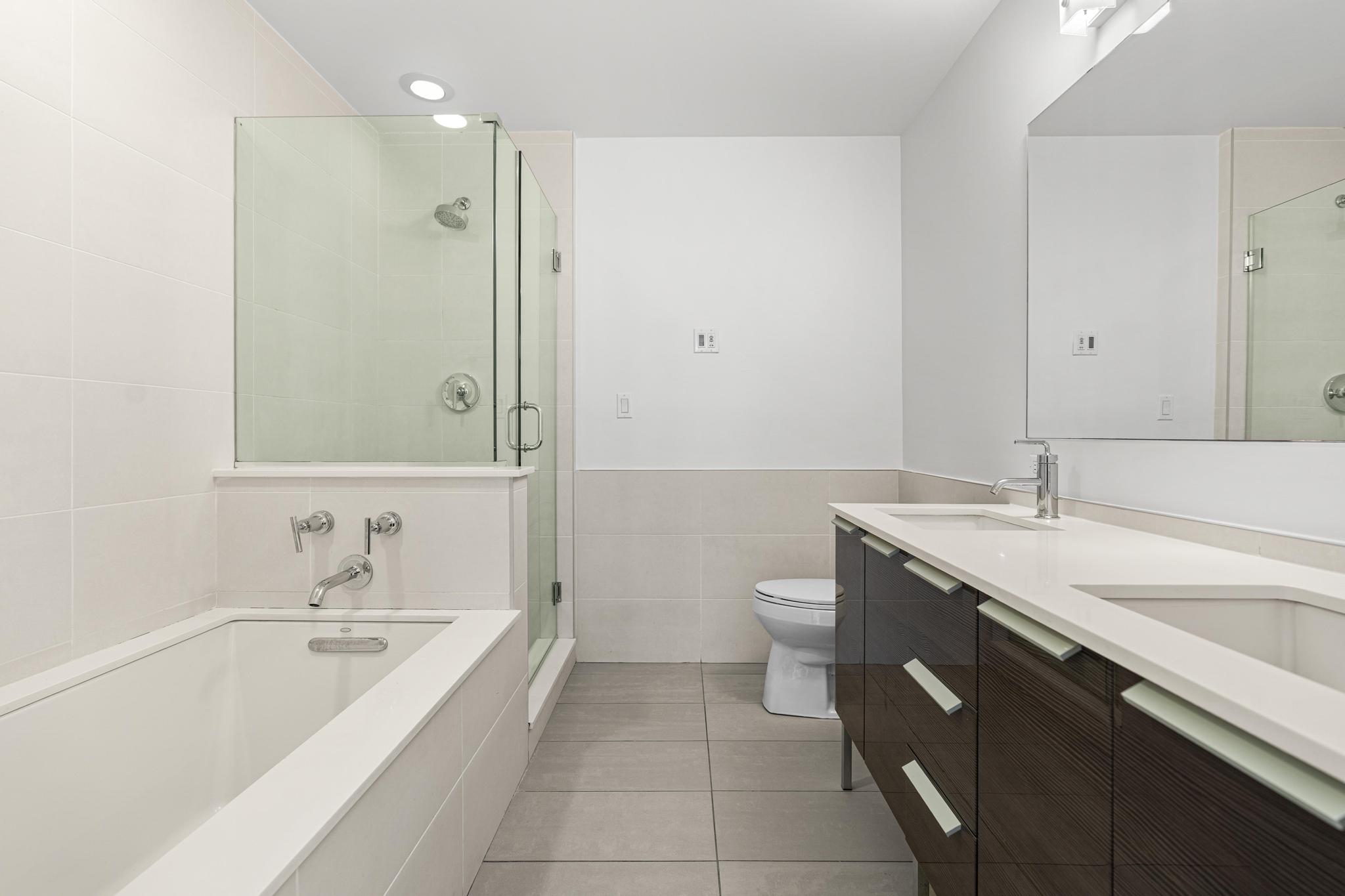 306 West 116th Street, Unit 1C Manhattan, NY 10026 - Photo 7 of 12 a bathroom with a tub sink and mirror