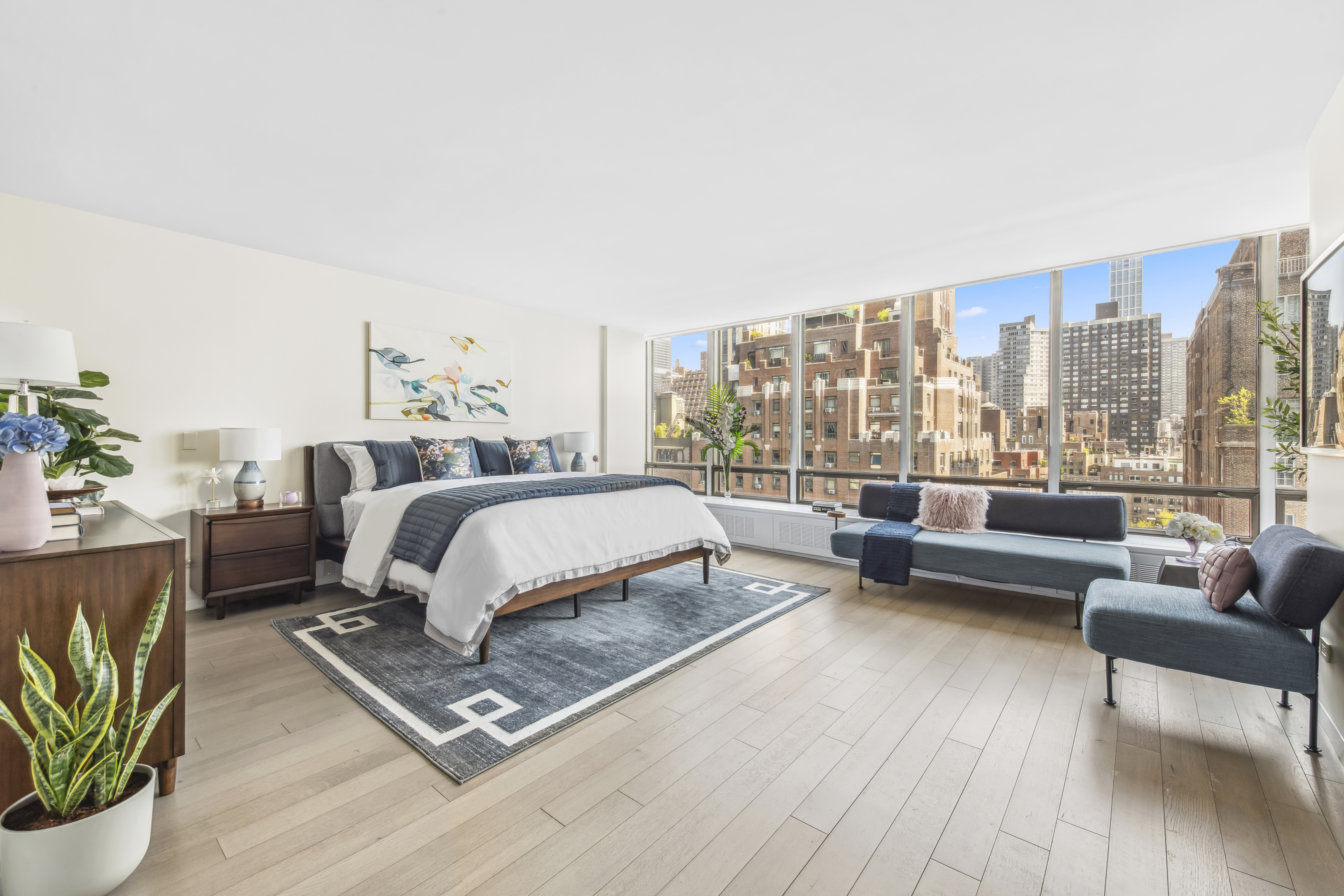 870 United Nations Plaza, Unit 15E Manhattan, NY 10017 - Photo 5 of 19 a bedroom with a bed couch and a large window