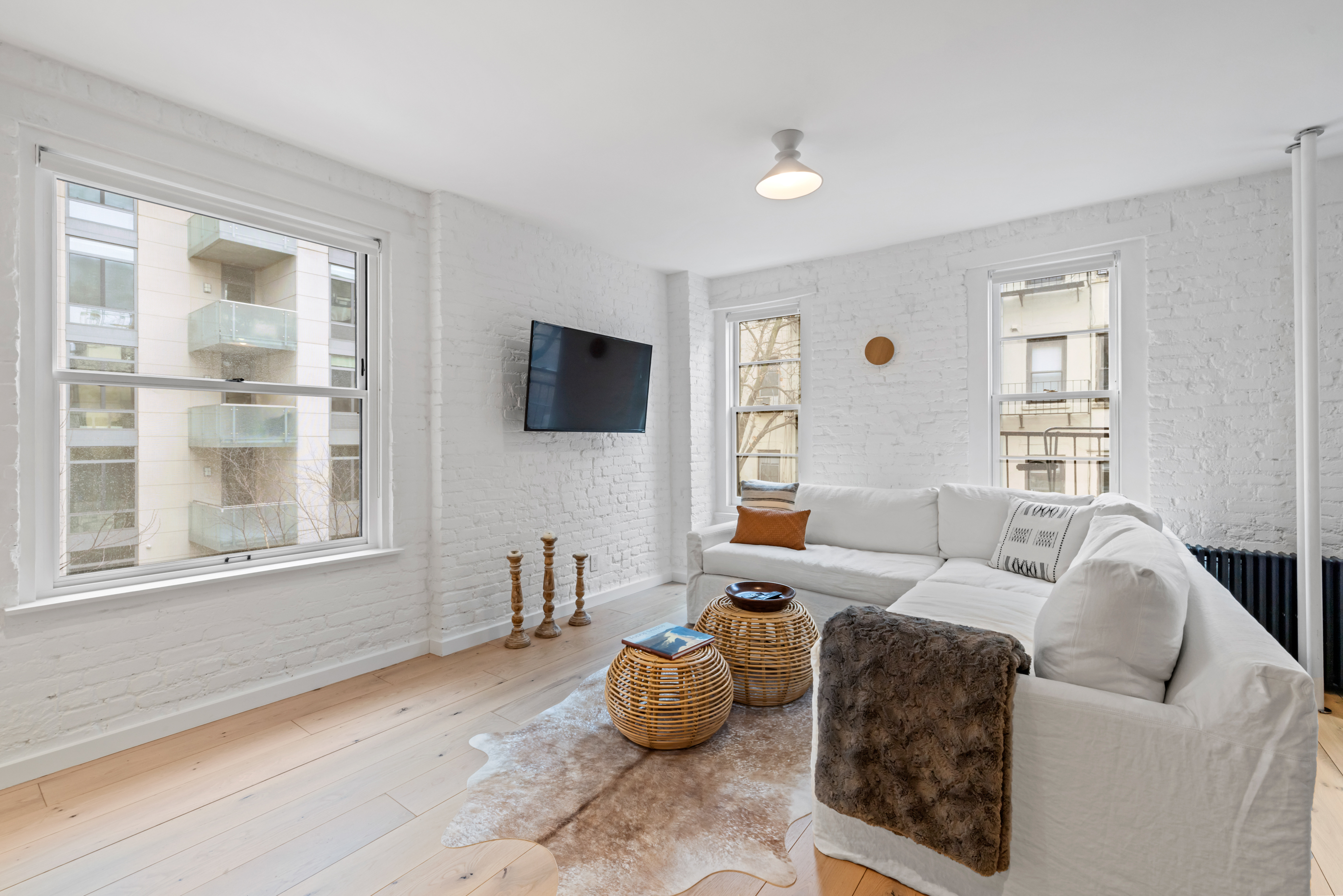 57 Thompson Street, Unit 4E Manhattan, NY 10012 - Photo 6 of 16 a living room with furniture and a flat screen tv