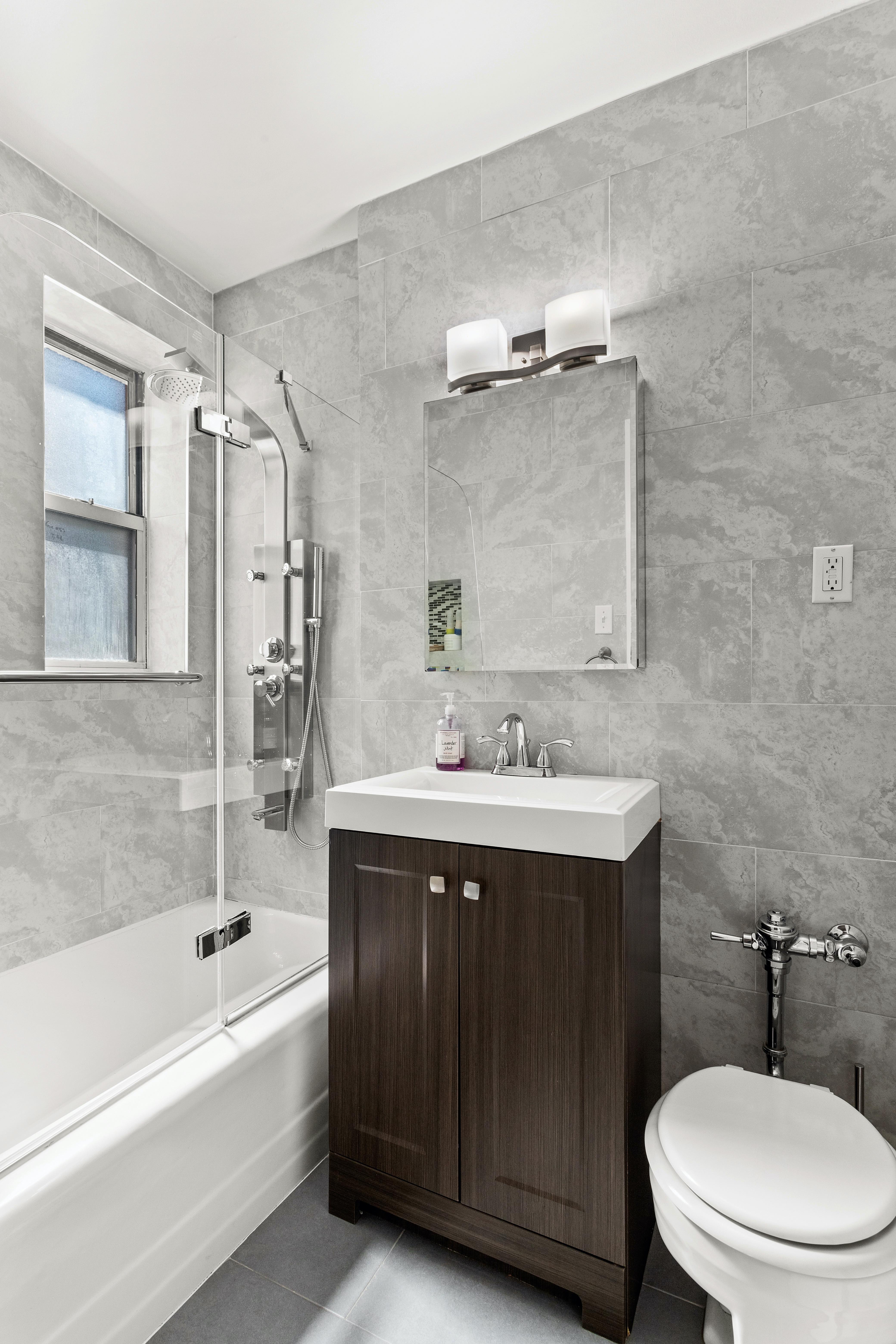 66 Overlook Terrace, Unit 4K Manhattan, NY 10040 - Photo 15 of 26 a bathroom with a sink a toilet and shower