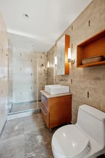 a bathroom with a sink a toilet and shower