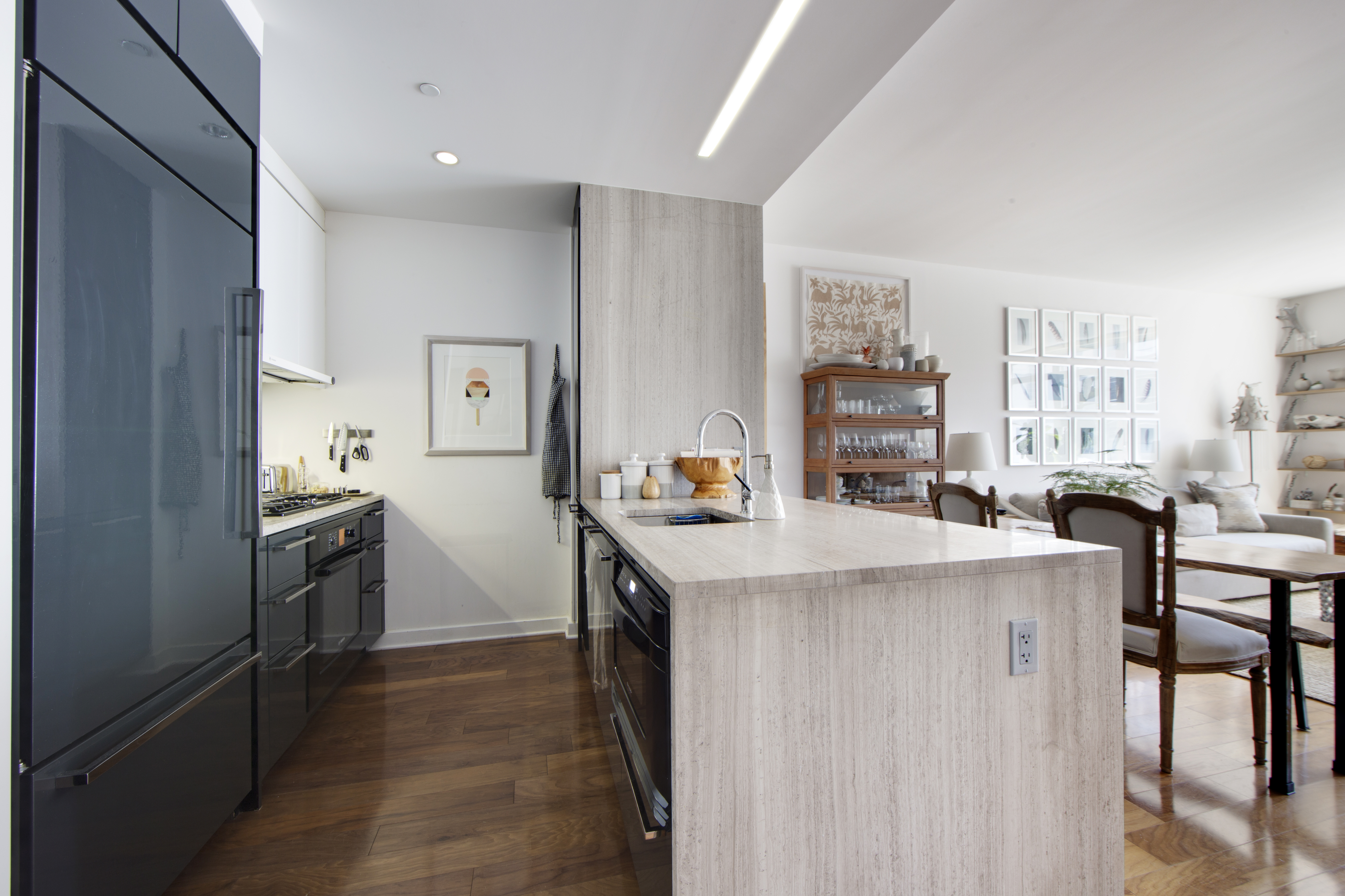 2 Northside Piers, Unit 4B Brooklyn, NY 11249 - Photo 7 of 18 a kitchen with kitchen island a stove a refrigerator a dining table and chairs with wooden floor