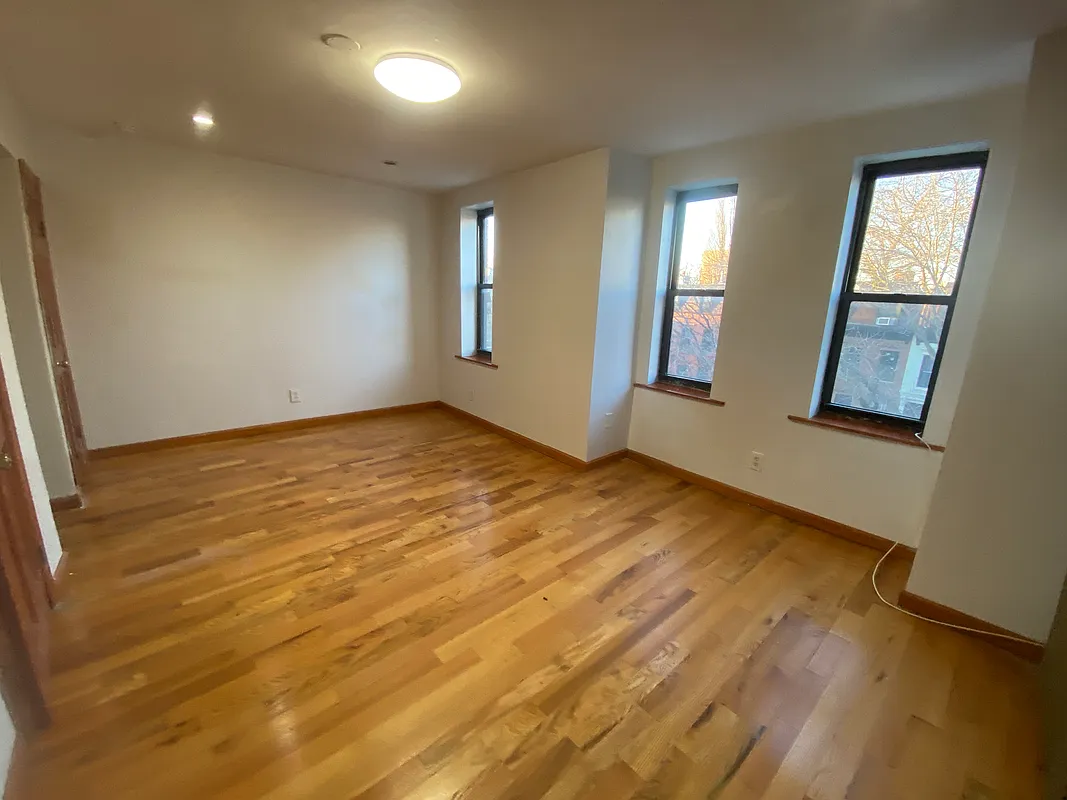 62 Bainbridge Street, Unit 4 Brooklyn, NY 11233 - Photo 4 of 8 an empty room with windows