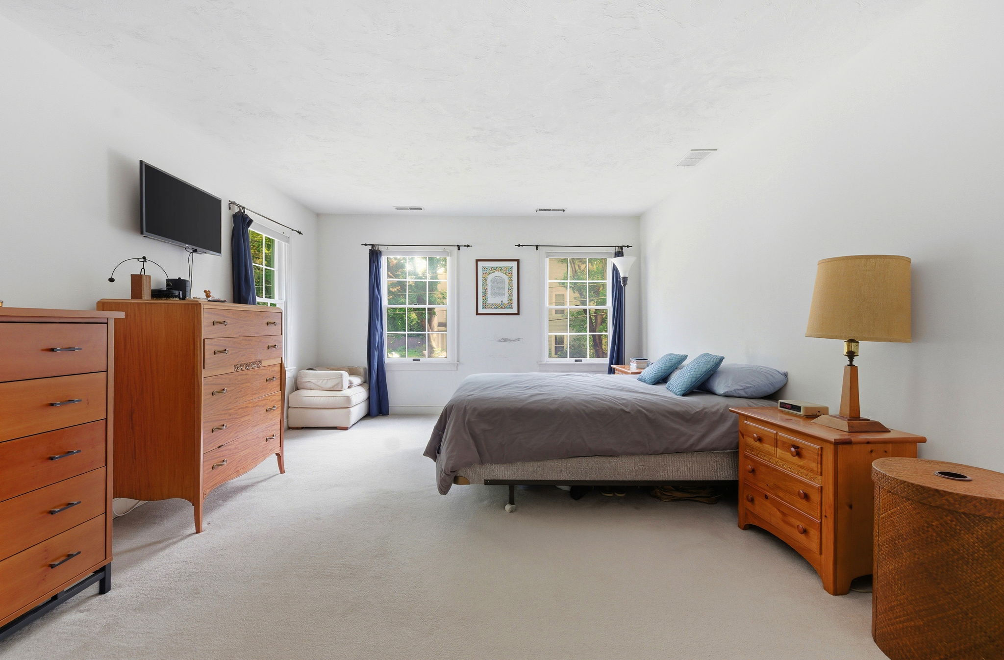 2 Laurel Street Lexington, MA 02421 - Photo 25 of 46 a spacious bedroom with a bed and a flat tv screen on dresser