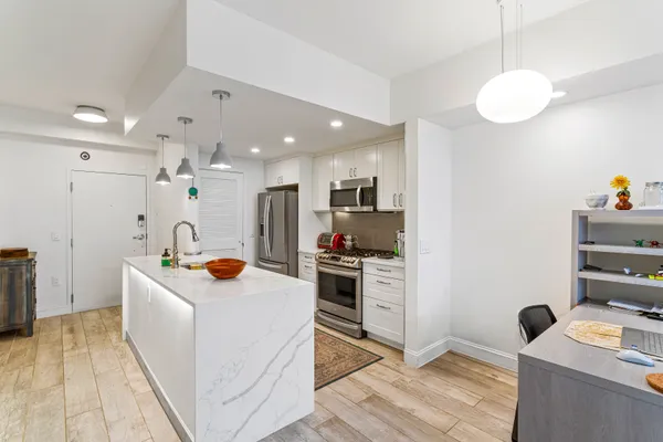 a kitchen with stainless steel appliances a stove microwave and refrigerator