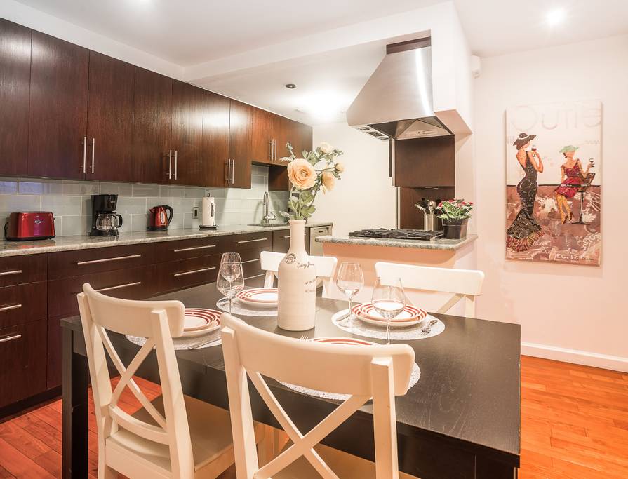 153 Stanton Street, Unit A1 Manhattan, NY 10002 - Photo 11 of 16 a kitchen with a dining table chairs and cabinets