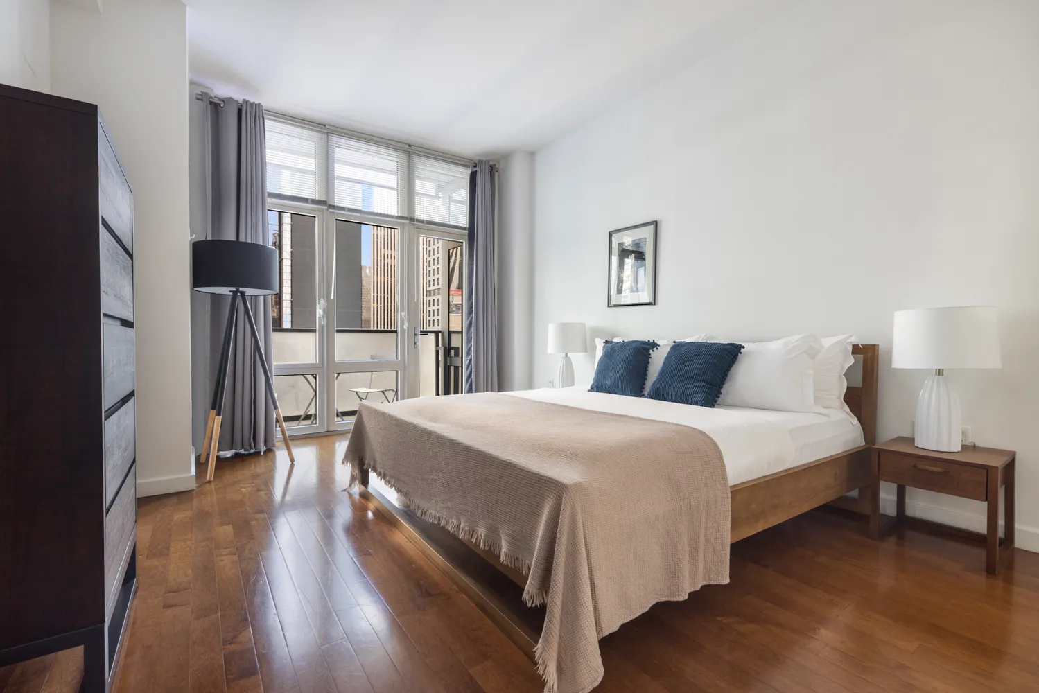 a bedroom with a bed and a large mirror next to a window
