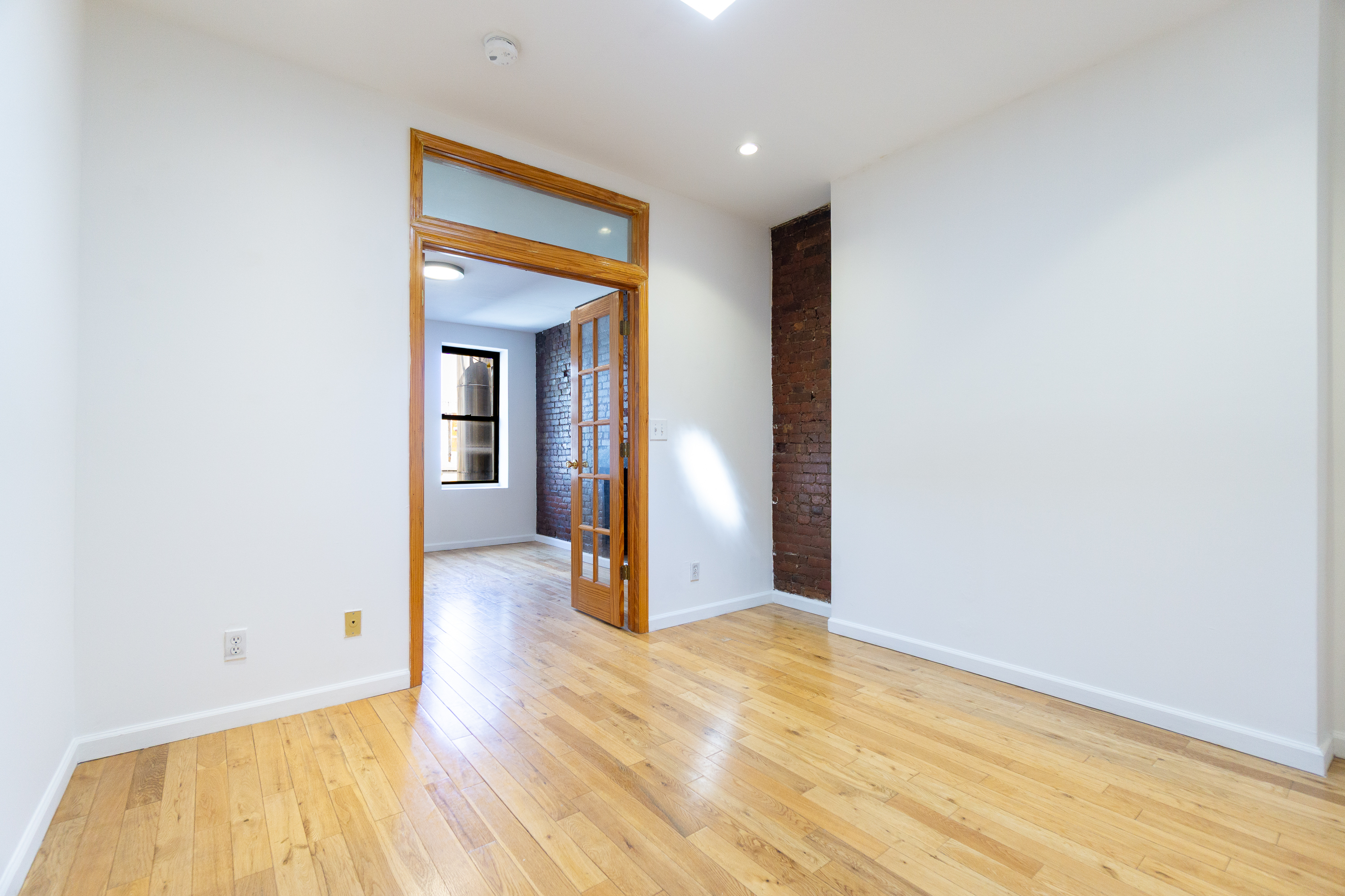 339 East 6th Street, Unit 14 Manhattan, NY 10003 - Photo 2 of 8 a view of a room with wooden floor and a ceiling fan