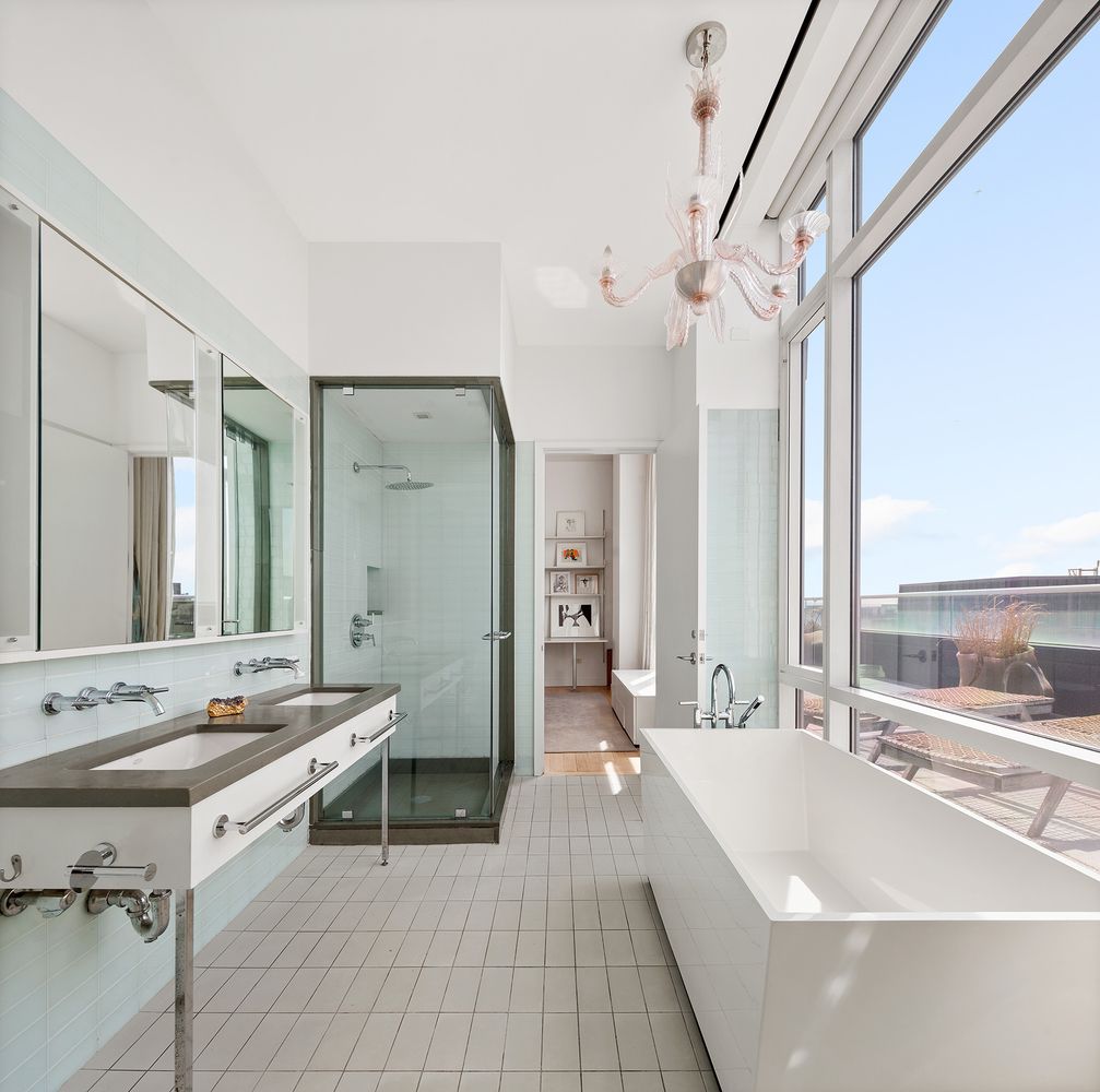 a spacious bathroom with a double vanity sink a mirror and a bathtub
