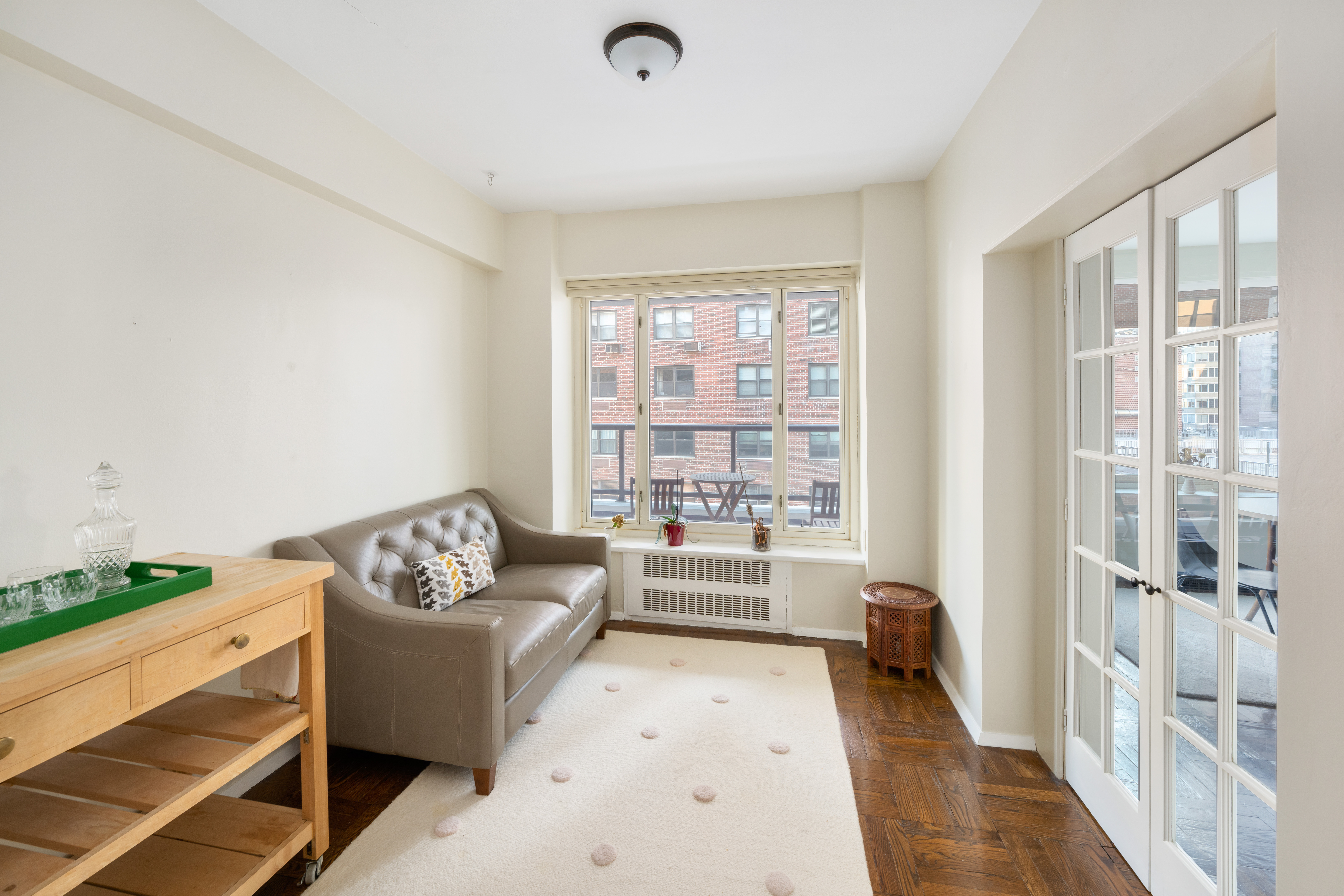 36 Sutton Place South, Unit 13D Manhattan, NY 10022 - Photo 6 of 9 a living room with furniture and a floor to ceiling window