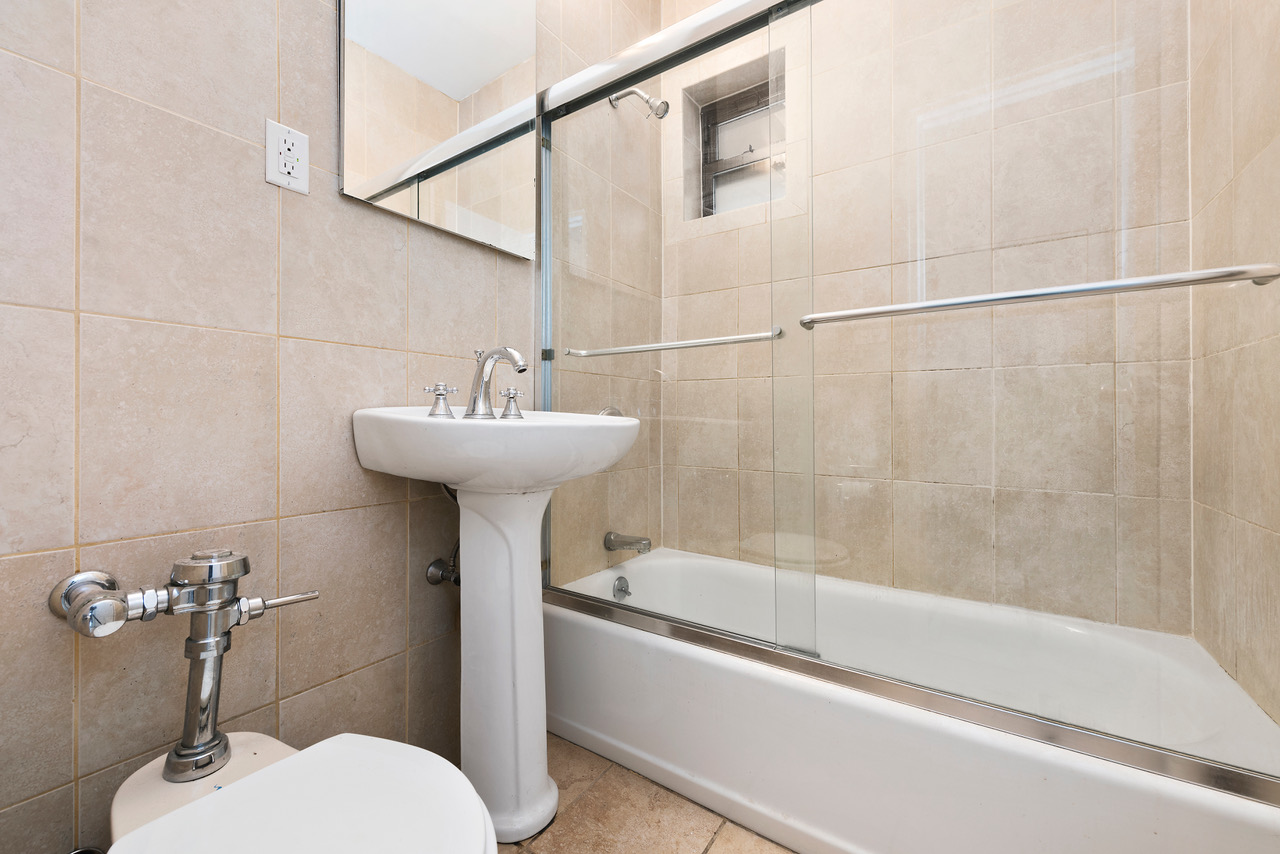 54 Jane Street Manhattan, NY 10014 - Photo 8 of 26 a bathroom with a sink mirror toilet and bathtub
