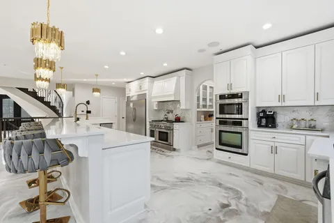 a kitchen with white cabinets and stainless steel appliances