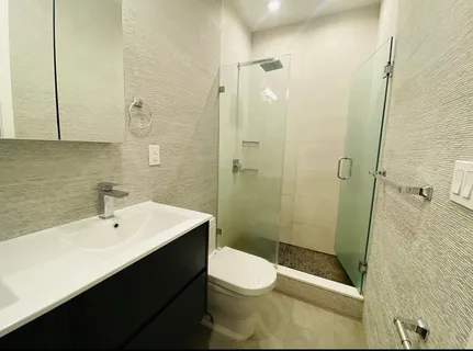 a bathroom with a sink a toilet and shower