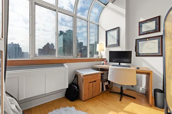 a view of a workspace with furniture and a window