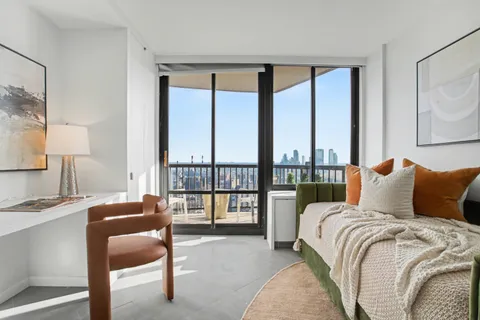 a living room with furniture and a floor to ceiling window