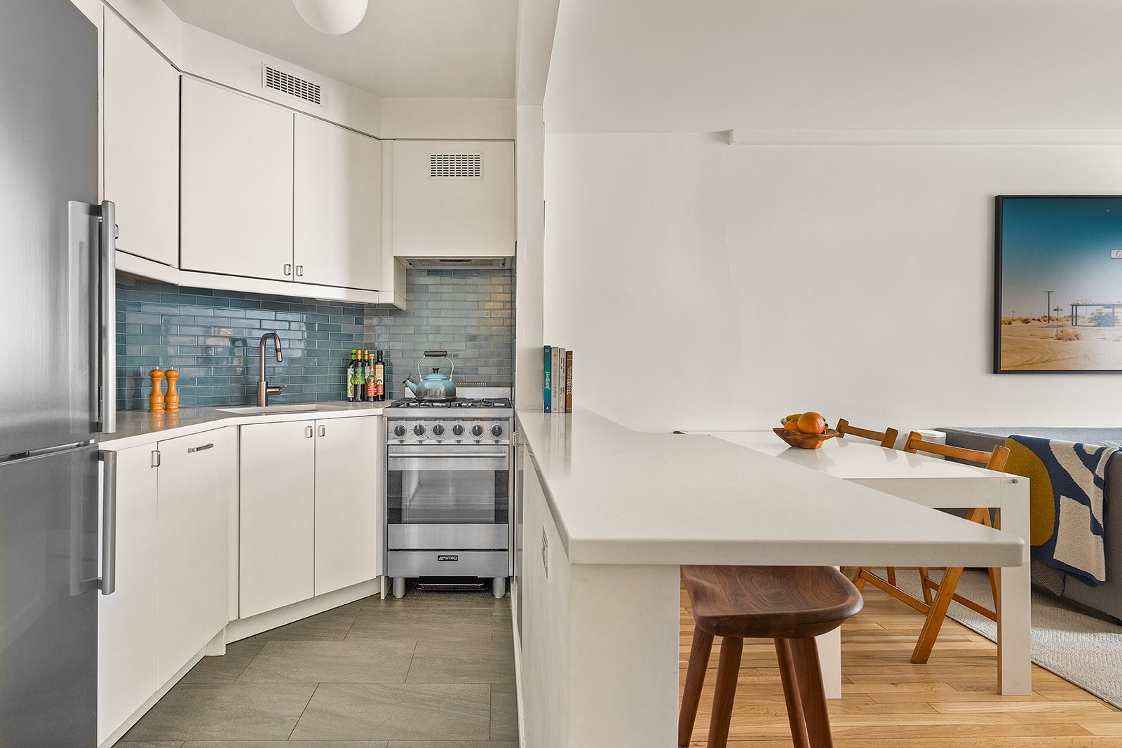 88 Bleecker Street, Unit 5G Manhattan, NY 10012 - Photo 2 of 9 a kitchen with a white cabinets and chairs