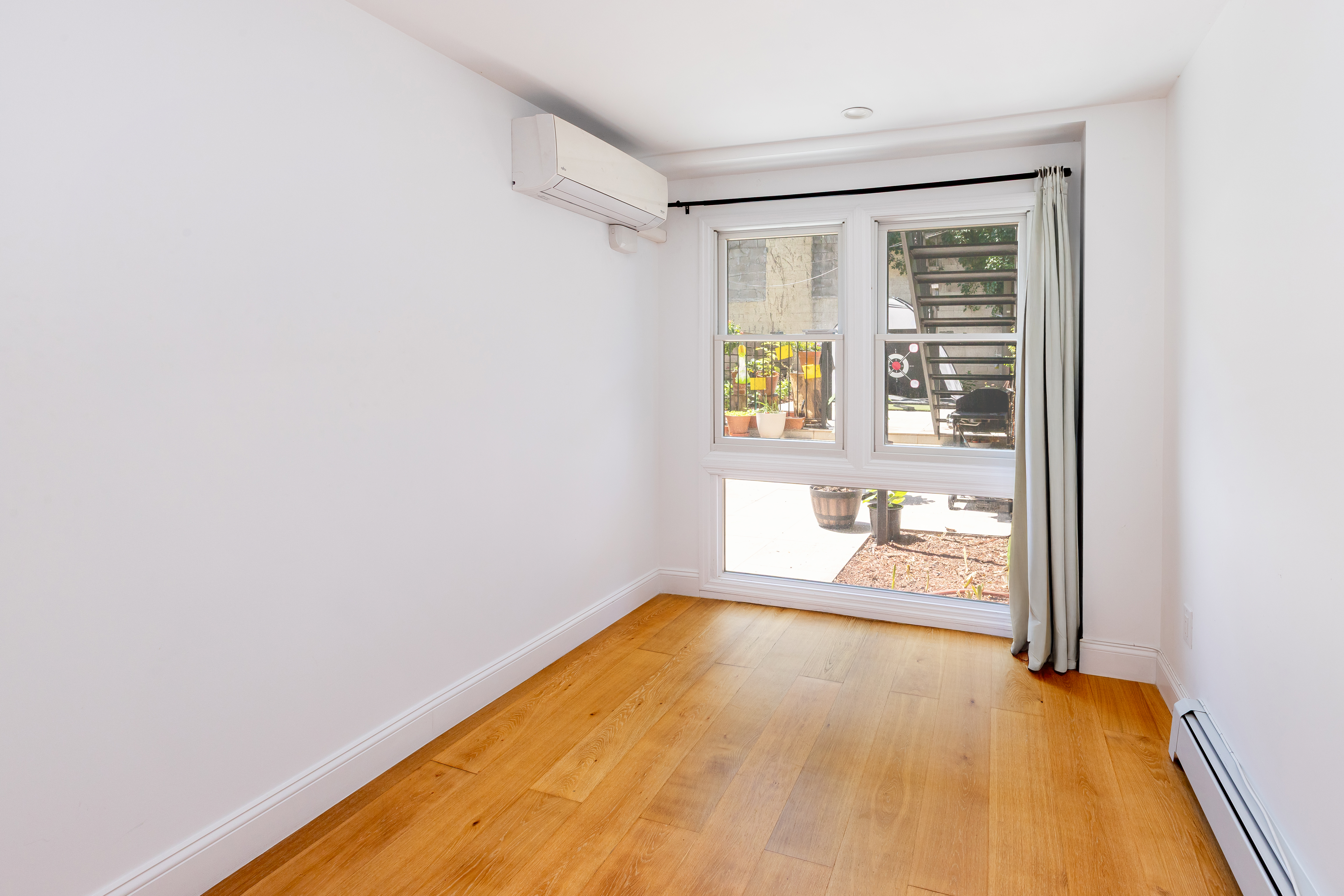 492 Warren Street, Unit GARDEN Brooklyn, NY 11217 - Photo 5 of 8 a view of an empty room with a window