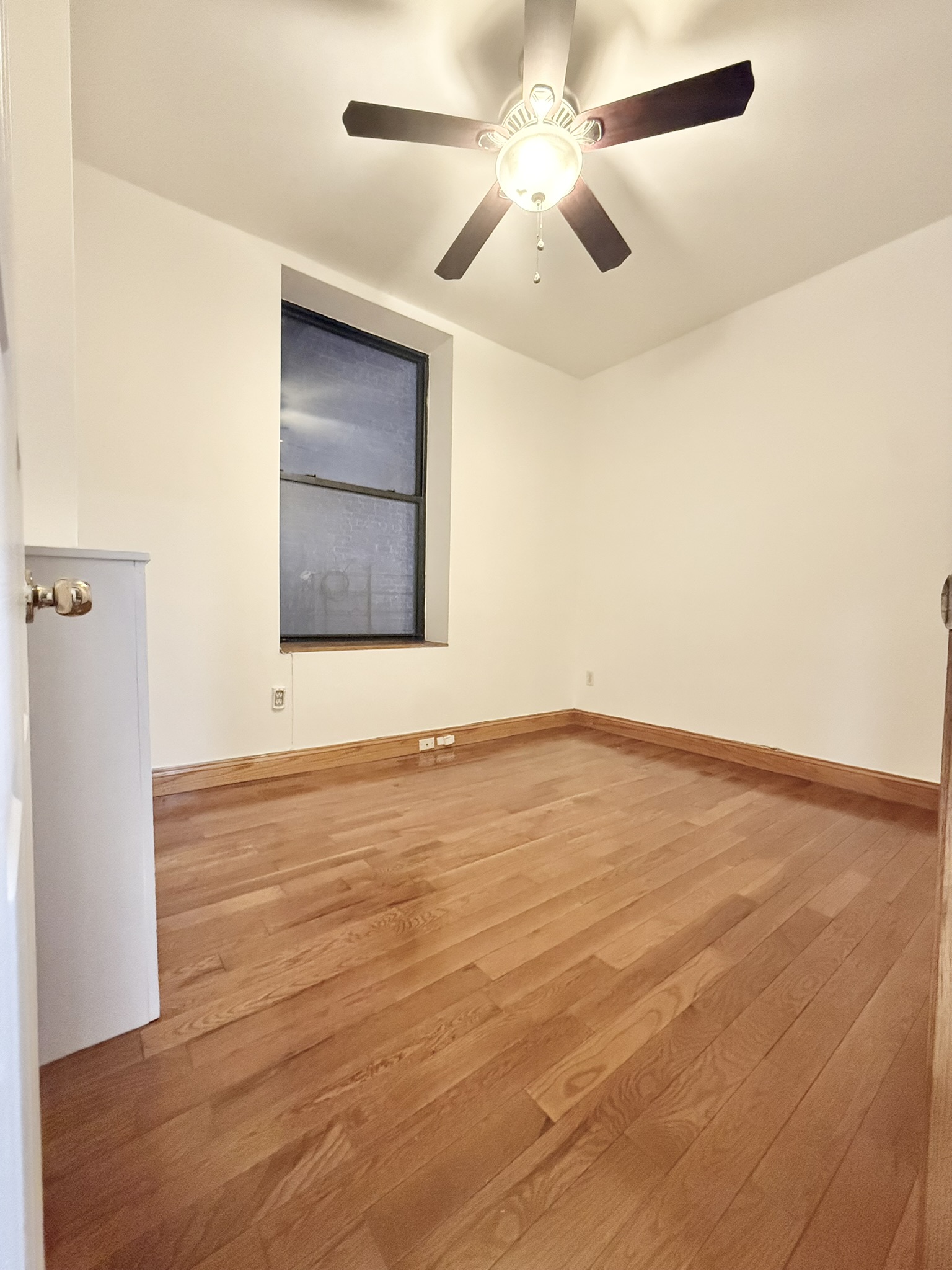 839 West End Avenue, Unit 3D Manhattan, NY 10025 - Photo 6 of 10 an empty room with a ceiling fan and wooden floor