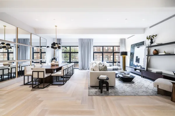 a living room with furniture kitchen view and large windows