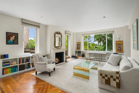 a living room with furniture fireplace and a large window