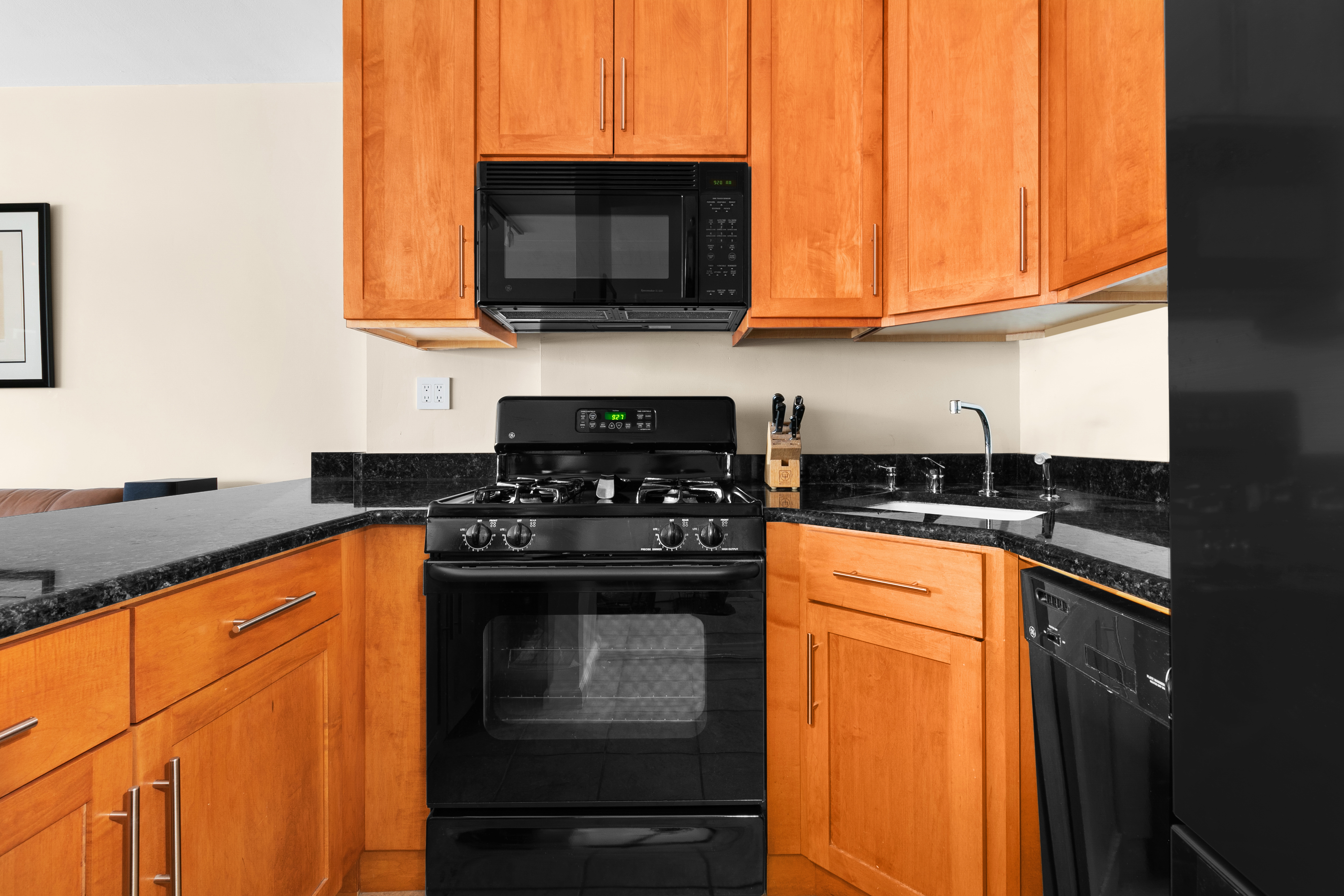 201 West 21st Street, Unit 8G Manhattan, NY 10011 - Photo 5 of 8 a kitchen with stainless steel appliances granite countertop a stove top oven microwave and cabinets