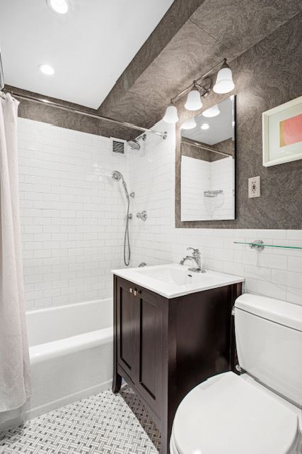 a bathroom with a sink a toilet and shower