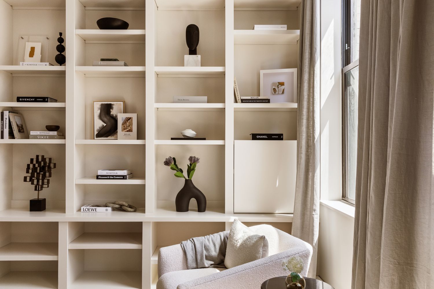 a living room with white cabinets and a window