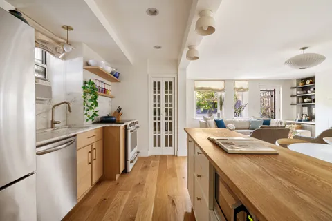 a kitchen that has a sink a stove and wooden floor