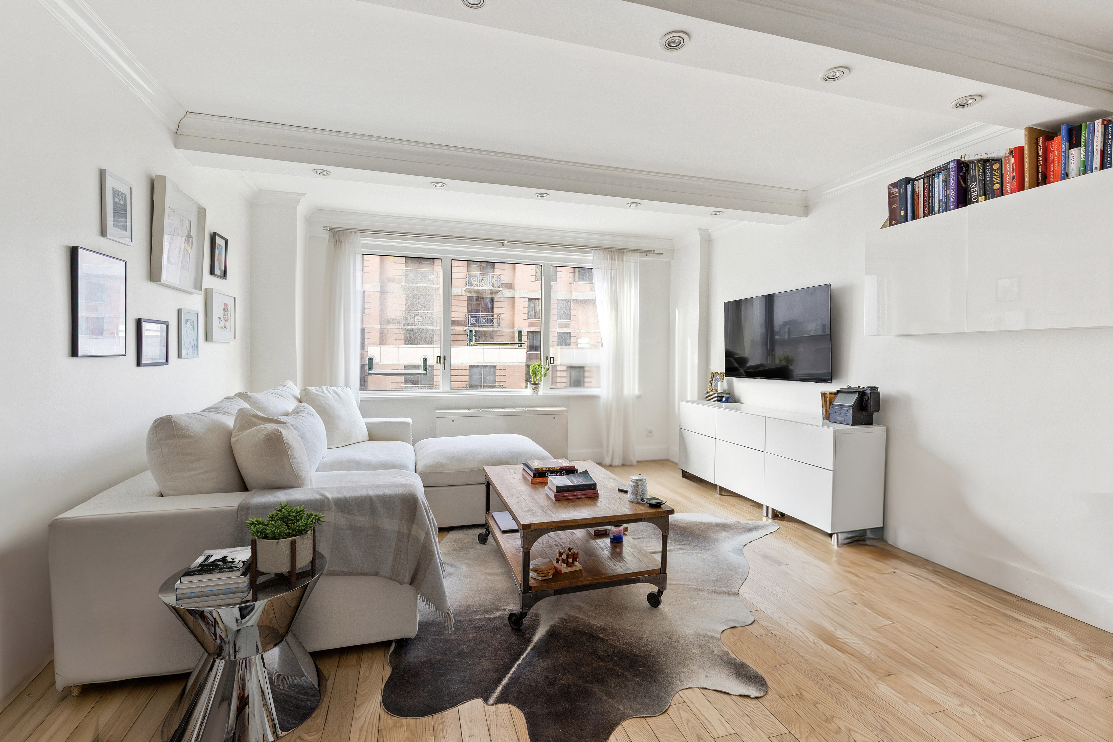 201 East 25th Street, Unit 7F Manhattan, NY 10010 - Photo 1 of 10 a living room with furniture and a flat screen tv
