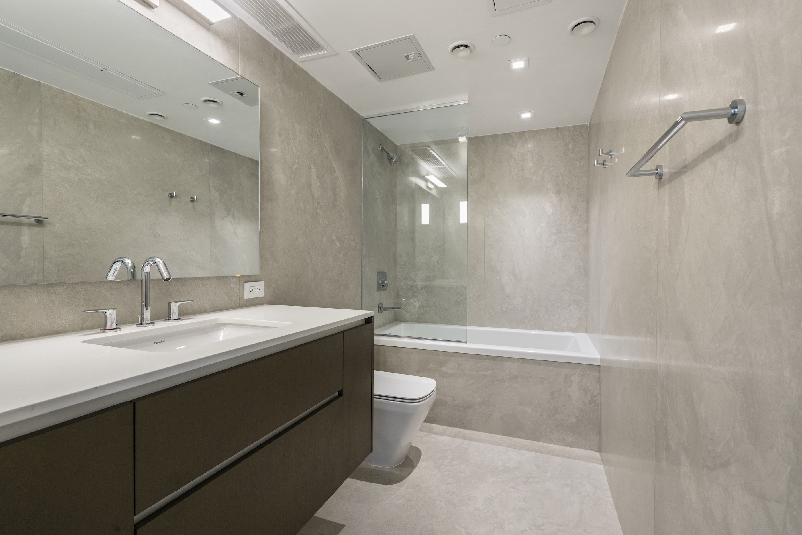 136 West Houston Street, Unit 6 Manhattan, NY 10012 - Photo 12 of 14 a bathroom with a granite countertop sink a toilet a mirror and shower