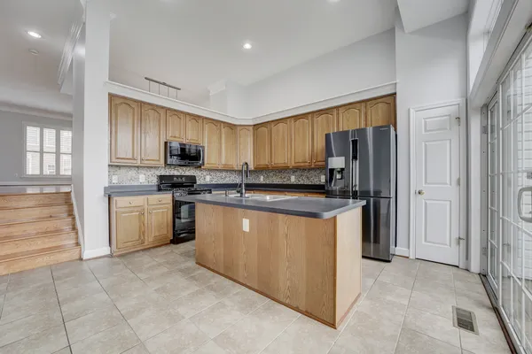 a kitchen with stainless steel appliances granite countertop a refrigerator stove top oven and sink