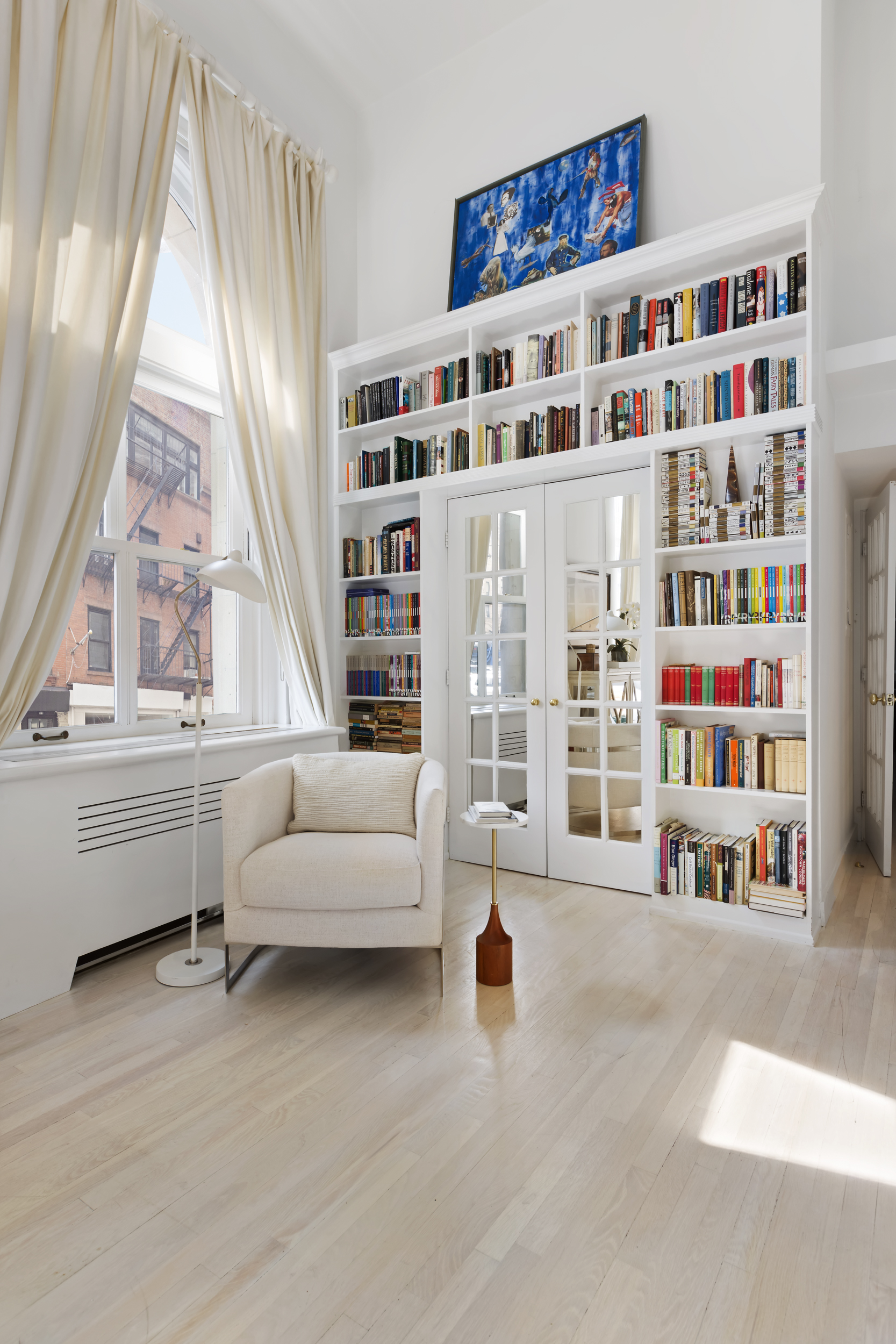 240 Centre Street, Unit 2J Manhattan, NY 10013 - Photo 10 of 18 a living room with furniture and a book shelf