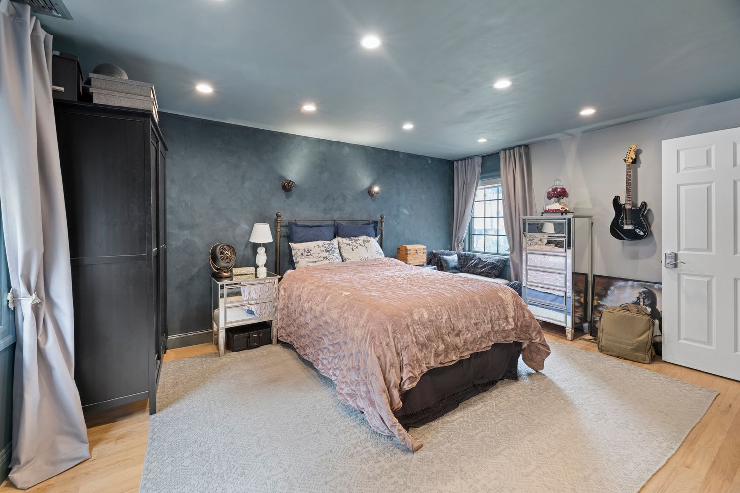 a large bedroom with bed and a large window