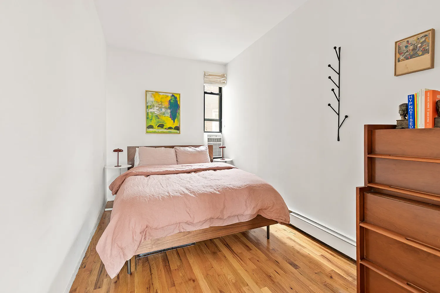 a bedroom with a bed and a wall painting