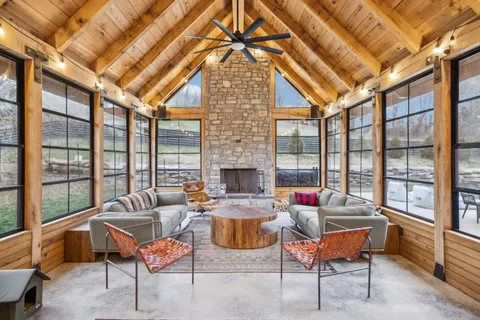 a dining room with furniture and a floor to ceiling window