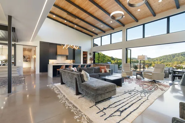 a kitchen with stainless steel appliances kitchen island granite countertop a stove top oven a sink a dining table and chairs with wooden floor