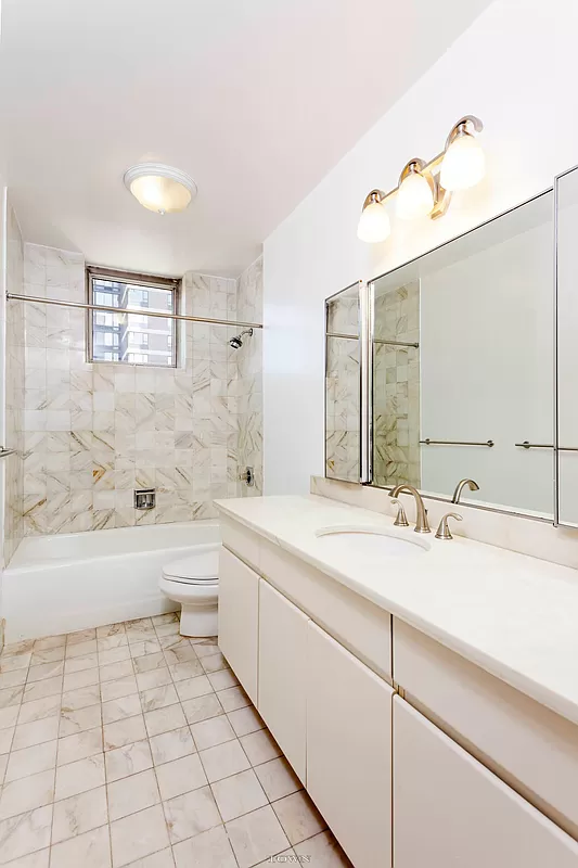 420 East 58th Street, Unit 17B Manhattan, NY 10022 - Photo 6 of 12 a bathroom with a bathtub a sink and a mirror