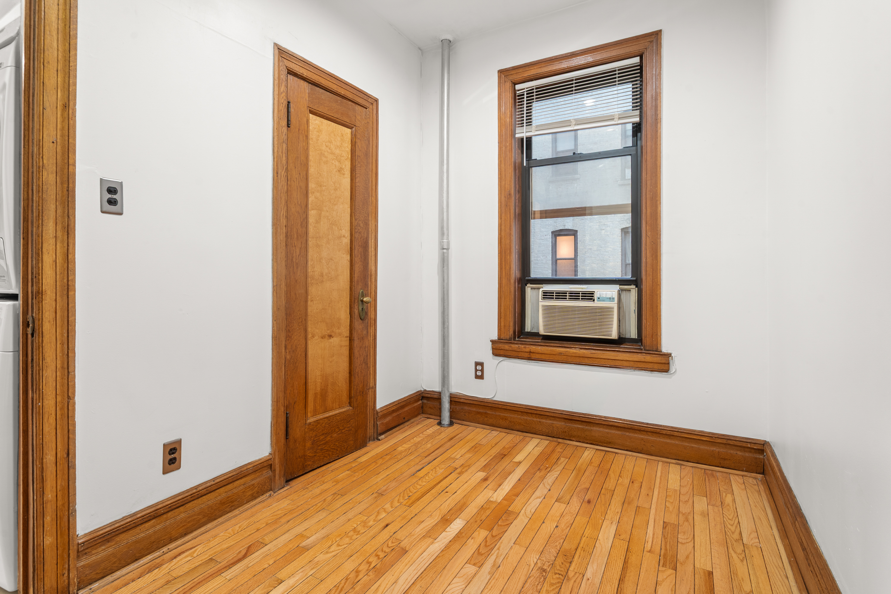 527 West 143rd Street, Unit 31 Manhattan, NY 10031 - Photo 22 of 29 a view of an empty room with window and wooden floor