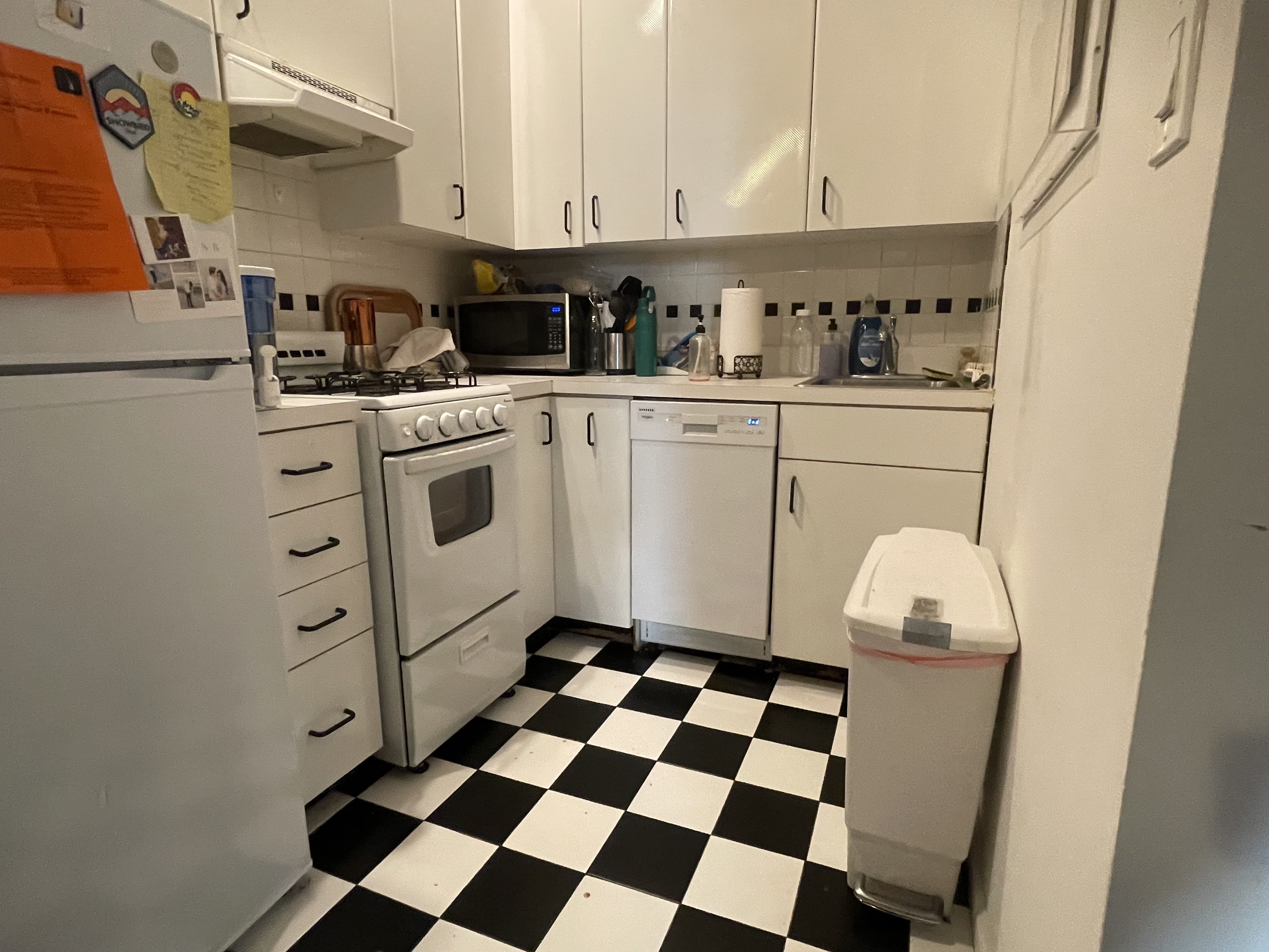 1716 2nd Avenue, Unit 4C Manhattan, NY 10128 - Photo 5 of 13 a kitchen with white cabinets a stove top oven and sink
