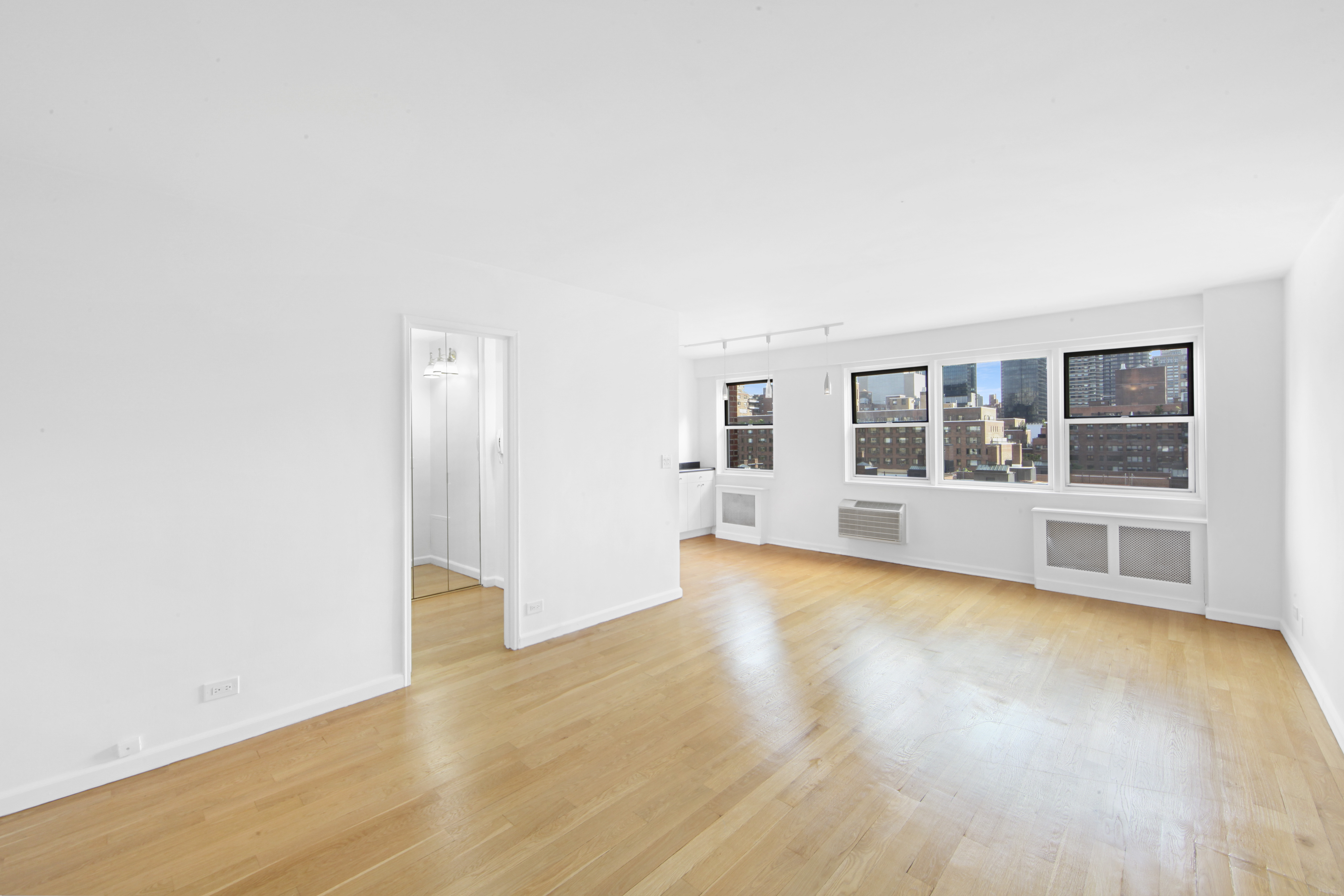 404 East 66th Street, Unit 11B Manhattan, NY 10065 - Photo 1 of 9 a view of empty room with wooden floor and fan