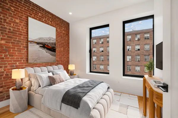 a bedroom with a bed and a flat tv screen on dresser