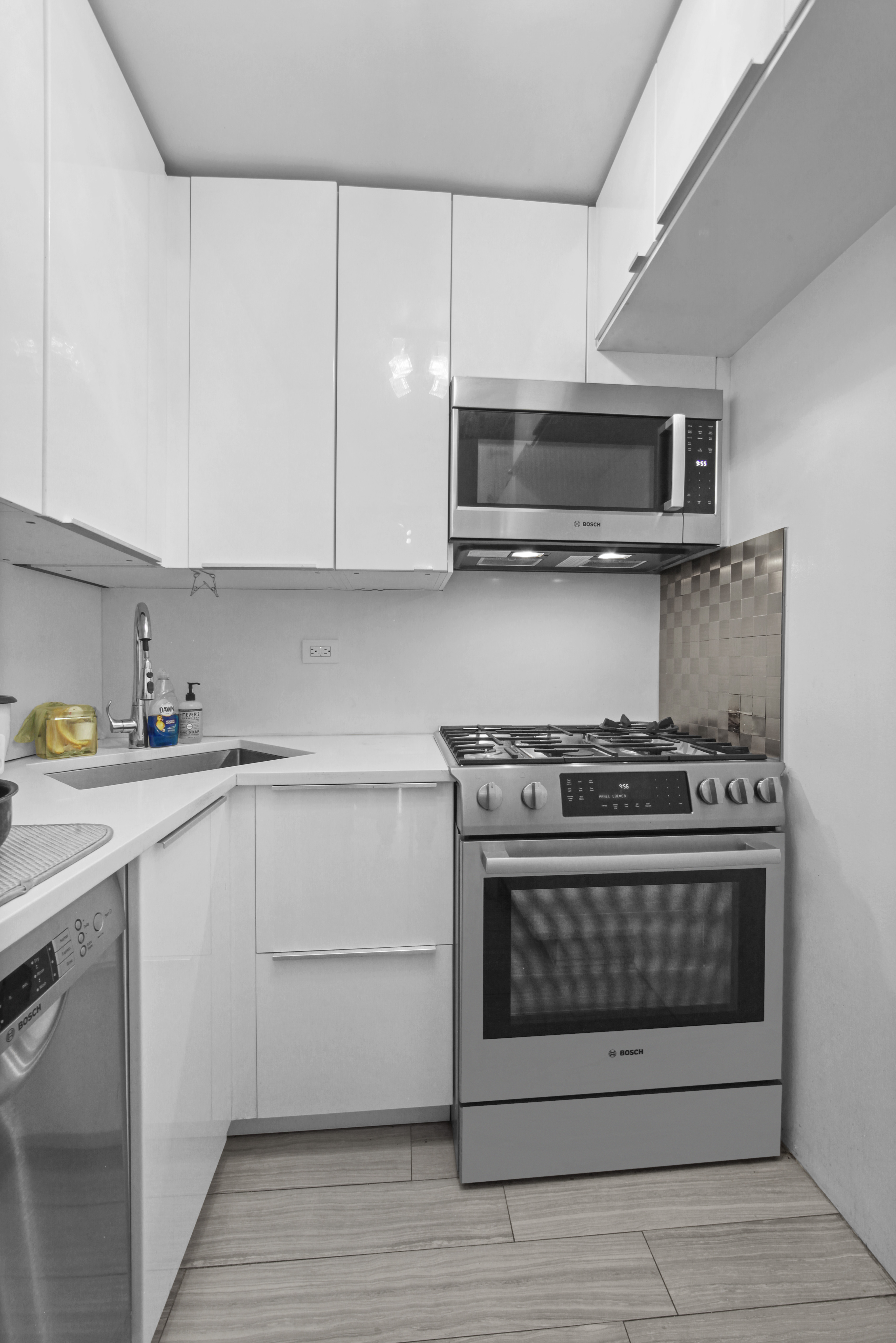 220 East 60th Street, Unit 5F Manhattan, NY 10022 - Photo 6 of 8 a kitchen with stainless steel appliances granite countertop a stove and a sink