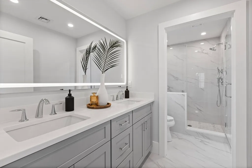 a bathroom with a sink a toilet and shower